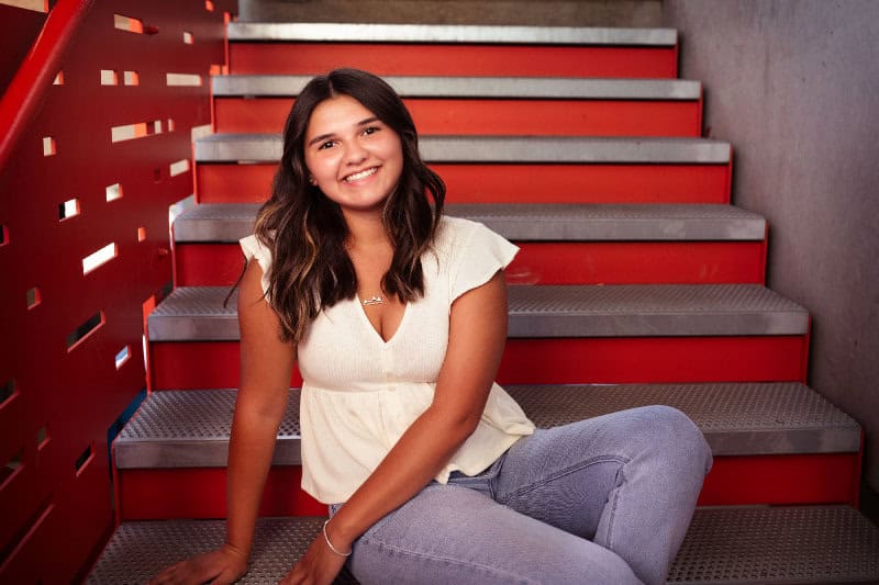 Alexis Johnson-Gonzalez posing for senior photo and smiling at the camera. 