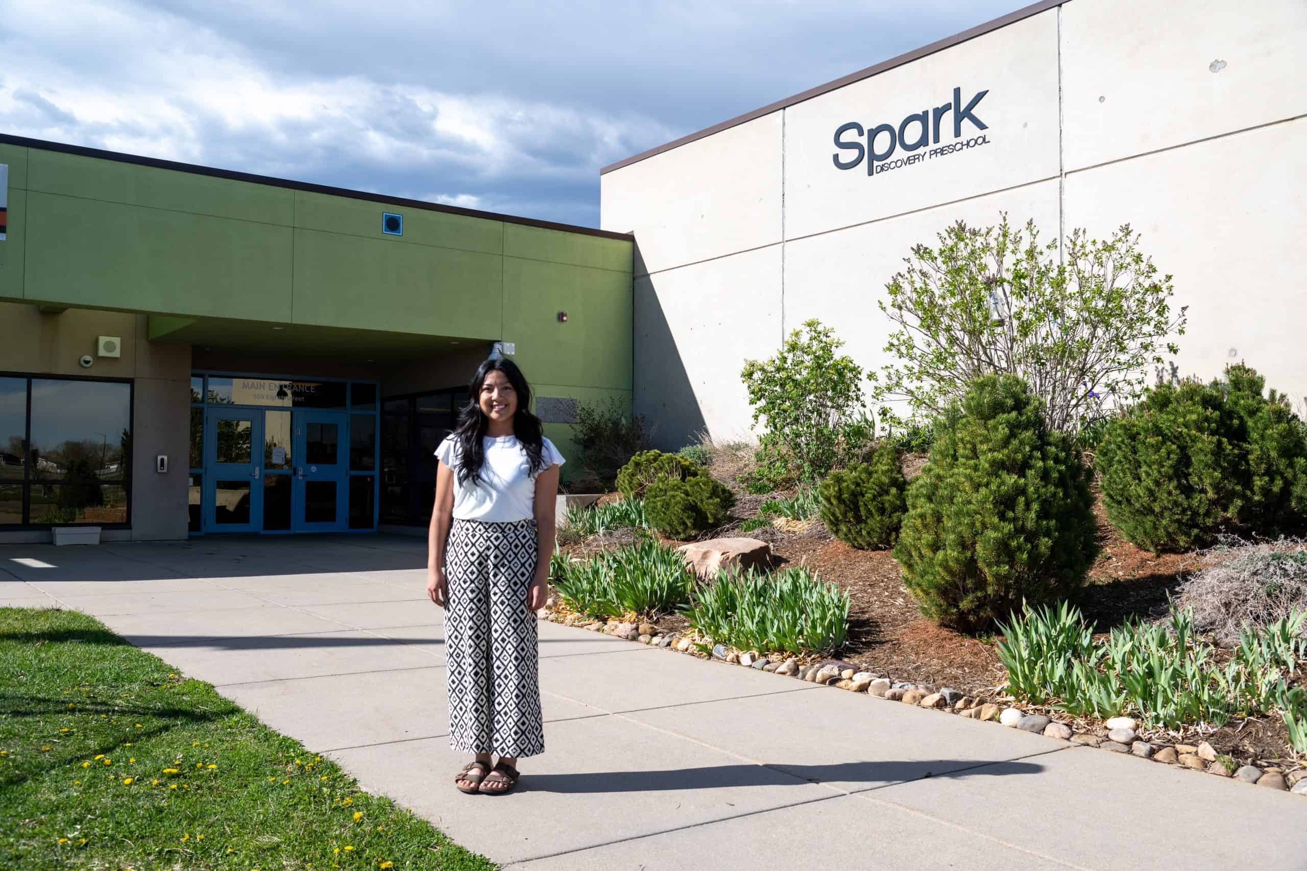 Ashley Rojas Carbajal stands in front of Spark! Discovery Preschool