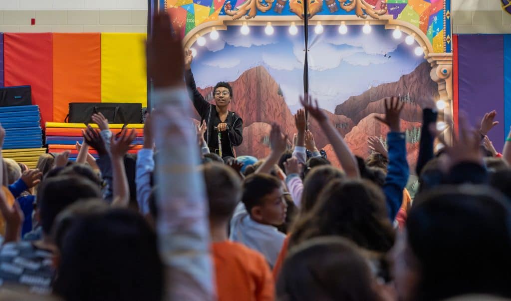 Actor asks questions to students during performance