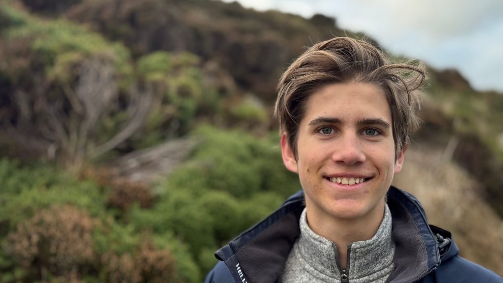 Carl Richter, a LaunchED Senior surrounded by lush greenery and rugged terrain under a cloudy sky.