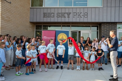 Se reúne una multitud mientras los niños se preparan para cortar una cinta roja en la ceremonia de inauguración del colegio Big Sky PK-8.