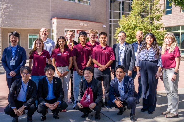 Group photo of Japanese delegation and St. Vrain staff outside a building labeled "Office".
